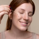 portrait-young-woman-pouring-serum-her-face